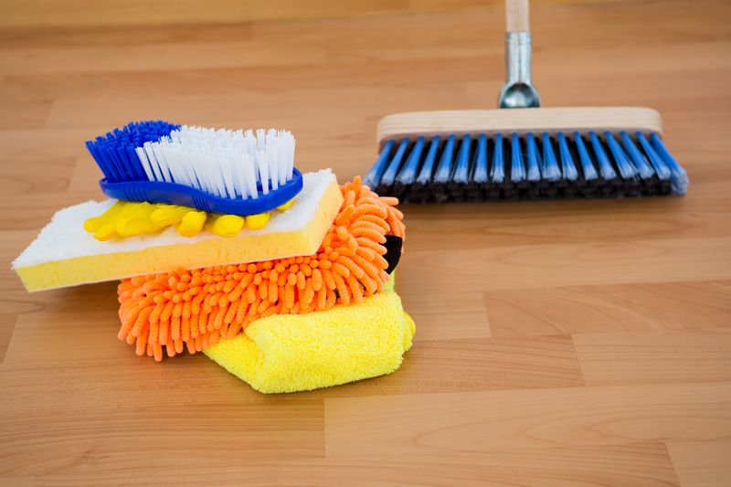 Household cleaning equipment on wooden floor