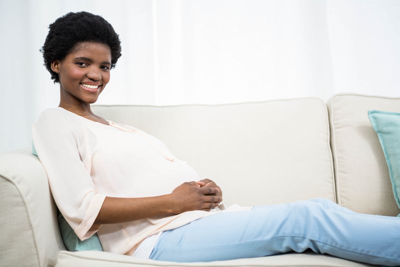 Pregnant woman sitting on sofa