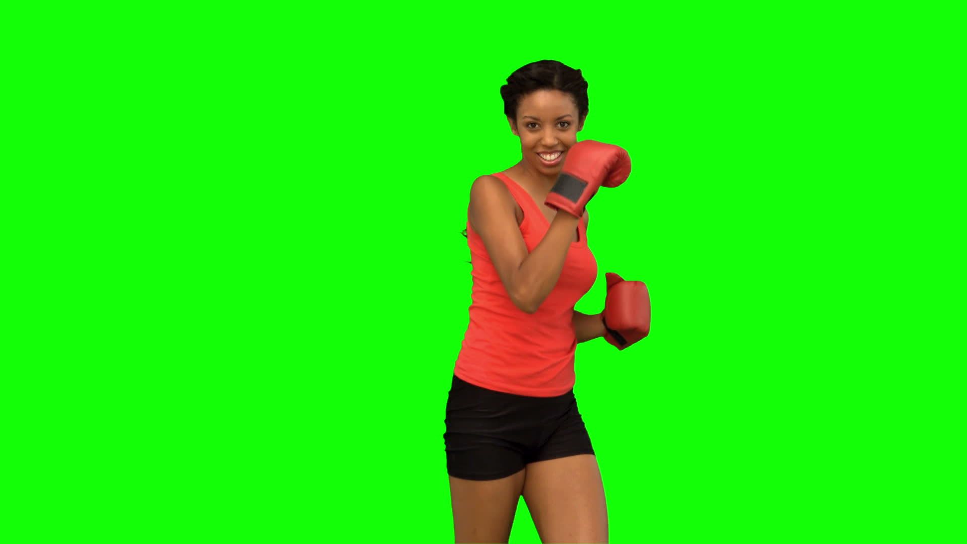 Female boxer training against green screen